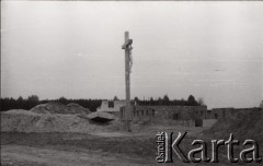 1973, Zbrosza Duża, powiat Grójec, Polska.
Budowa kościoła zainicjowana przez księdza Czesława Sadłowskiego w 1969 r., pozwolenie na budowę uzyskano w roku 1972, prace rozpoczęto 6 marca 1973. Budowa, której patronował kardynał Stefan Wyszyński była w okresie PRL-u symbolem oporu wobec władzy państwowej. Krzyż z figurą ukrzyżowanego Chrystusa na placu budowy.
Fot. NN, zbiory Ośrodka KARTA, udostępnił ks. Czesław Sadłowski