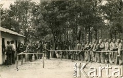 Lata 30., Brześć nad Bugiem, woj. poleskie, Rzeczpospolita Polska.
Teren Garnizonu Brześć. Wydawanie posiłków uczniom Średniej Szkoły Technicznej im. Marszałka Józefa Piłsudskiego uczestniczącym w szkoleniu hufca Przysposobienia Wojskowego.
Szkoła powstała w 1923 roku z inicjatywy inżyniera Oktawiusza Nelarda jako Szkoła Średnia Techniczna Kolejowa.
Fot. NN, kolekcja Eugeniusza Lewickiego, zbiory Ośrodka KARTA