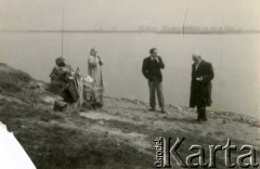 Lata 40.-50., brak miejsca.
Architekt Eugeniusz Lewicki w towarzystwie mężczyzny oraz kobiety stoi przy brzegu zbiornika wodnego.
Fot. NN, kolekcja Eugeniusza Lewickiego, zbiory Ośrodka KARTA