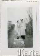 Po 1952, prawdopodobnie Polska.
Eugeniusz Lewicki w towarzystwie młodej kobiety, prawdopodobnie swojej żony, Krystyny Tekli Lewickiej z domu Barankiewicz. Para pozuje do zdjęcia na dróżce wyłożonej kamiennymi płytami.
Fot. NN, kolekcja Eugeniusza Lewickiego, zbiory Ośrodka KARTA