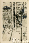 1929-1939, okolice Brześcia nad Bugiem, woj. poleskie, Rzeczpospolita Polska.
Robotnicy wznoszą drewnianą konstrukcję uszczelnioną smołą. Kanał Muchawiecki (Kanał Dniepr-Bug, zwany również Kanałem Królewskim lub Kanałem Rzeczypospolitej) otwarty w 1848 roku kanał żeglowny łączący Dniepr z Wisłą poprzez Pinę (dopływ Prypeci) i Muchawiec (prawostronny dopływ Bugu) stanowiący część szlaku wodnego łączącego Morze Bałtyckie z Morzem Czarnym. Pierwszy odcinek Kanału zbudowano w latach 1775-1784, następnie, w latach 1846-1848, Kanał był rozbudowywany przez władze rosyjskie. W latach 1929-1939, w czasach administracji II Rzeczypospolitej, poddawany gruntowym pracom remontowym. 
Fot. NN, kolekcja Eugeniusza Lewickiego, zbiory Ośrodka KARTA