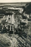 1929-1939, okolice Brześcia nad Bugiem, woj. poleskie, Rzeczpospolita Polska.
Teren budowy w rejonie rzeki Muchawiec. Na dalszym planie widoczne rozlewiska rzeki. 
Kanał Muchawiecki (Kanał Dniepr-Bug, zwany również Kanałem Królewskim lub Kanałem Rzeczypospolitej) otwarty w 1848 roku kanał żeglowny łączący Dniepr z Wisłą poprzez Pinę (dopływ Prypeci) i Muchawiec (prawostronny dopływ Bugu)  stanowiący część szlaku wodnego łączącego Morze Bałtyckie z Morzem Czarnym. Pierwszy odcinek Kanału zbudowano w latach 1775-1784, następnie, w latach 1846-1848, Kanał był rozbudowywany przez władze rosyjskie. W latach 1929-1939, w czasach administracji II Rzeczypospolitej, poddawany gruntowym pracom remontowym. 
Fot. NN, kolekcja Eugeniusza Lewickiego, zbiory Ośrodka KARTA