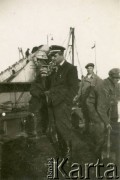 1929-1939, okolice Brześcia nad Bugiem, woj. poleskie, Rzeczpospolita Polska.
Urzędnik państwowy oraz robotnicy podczas pracy na brzegu rzeki. W tle widoczna pracująca na wodzie pogłębiarka.
Kanał Muchawiecki (Kanał Dniepr-Bug, zwany również Kanałem Królewskim lub Kanałem Rzeczypospolitej) otwarty w 1848 roku kanał żeglowny łączący Dniepr z Wisłą poprzez Pinę (dopływ Prypeci) i Muchawiec (prawostronny dopływ Bugu) stanowiący część szlaku wodnego łączącego Morze Bałtyckie z Morzem Czarnym. Pierwszy odcinek Kanału zbudowano w latach 1775-1784, następnie, w latach 1846-1848, Kanał był rozbudowywany przez władze rosyjskie. W latach 1929-1939, w czasach administracji II Rzeczypospolitej, poddawany gruntowym pracom remontowym. 
Fot. NN, zbiory Ośrodka KARTA
