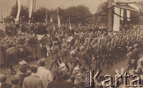 02-11.11.1938, Karwina, Zaolzie.
Przemarsz Wojska Polskiego z pocztem sztandarowym. Reprodukcja pocztówki z cyklu wydanego nakładem Polskiego Towarzystwa Księgarń Kolejowych 