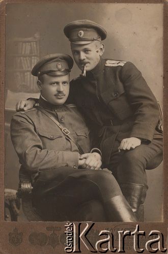 1914-1917, Moskwa, Rosja.
 Oficerowie armii rosyjskiej, lekarze, siedzi doktor Eugeniusz Budzyński. Na pagonie żołnierza z prawej widoczny czerwony krzyż, oznaka lekarza w armii carskiej, przy pasie szabla Dragonka wz. 1881.
 Fot. K.K. Bułła (Newski Prospekt 54), zbiory Ośrodka KARTA, udostępnił Stanisław Blichiewicz
   
