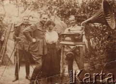 1921-1926, brak miejsca, Polska.
 Kobieta i trzech oficerów Wojska Polskiego - z prawej stoi doktor Eugeniusz Budzyński - przy gramofonie i aparacie fotograficznym na statywie, w tle namiot.
 Fot. NN, zbiory Ośrodka KARTA, udostępnił Stanisław Blichiewicz
   
