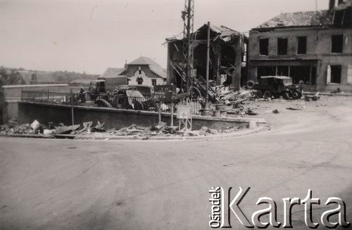 Czerwiec 1940, departament Aisne, Pikardia, Francja.
 Zniszczone miasteczko. Na pierwszym planie widoczny drogowskaz z nazwami miejscowości BP. Unehamel 7 km; Aubenton 15 km; w tle zniszczone pojazdy i zburzone budynki.
 Fot. NN, zbiory Ośrodka KARTA, udostępnił Stanisław Blichiewicz
   
