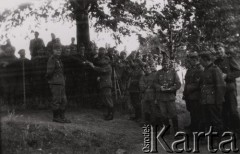 1940, Francja.
 Jeńcy francuscy za ogrodzeniem obozu i żołnierze niemieccy - od lewej szeregowy, kapral, szeregowy, kapral - trzyma w rękach aparat fotograficzny, trzej szeregowi, kapral, szeregowy.
 Fot. NN, zbiory Ośrodka KARTA, udostępnił Stanisław Blichiewicz
    
