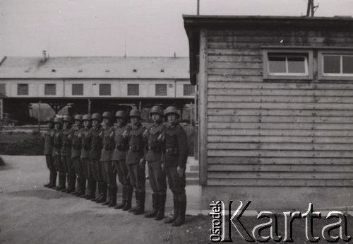 1940, Francja.
 Żołnierze jednostki wartowniczej Wehrmachtu – oddział warty w obozie dla jeńców francuskich. Żołnierze mają nieregulaminowe wyposażenie: hełmy starego typu 1916-18, austriackie kurtki i ładownice do Manlichera.
 Fot. NN, zbiory Ośrodka KARTA, udostępnił Stanisław Blichiewicz
   
