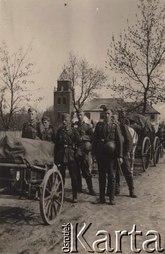 1940, Francja.
 Kolumna  wojsk niemieckich. Na pierwszym planie bietka z wymalowanym herbem Berlina; następnie sześciu żołnierzy Wehrmachtu - w pierwszym szeregu od lewej szeregowy, kapral, kapral, w drugim szeregu trzech szeregowych. Na dalszym planie widoczne wozy taborowe.
 Fot. NN, zbiory Ośrodka KARTA, udostępnił Stanisław Blichiewicz
   
