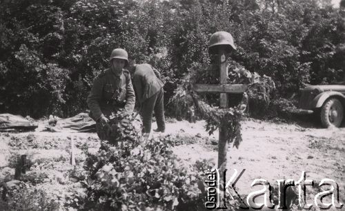 Czerwiec 1940, Francja.
 Grzebanie poległych żołnierzy Wehrmachtu, hełm na krzyżu.
 Fot. NN, zbiory Ośrodka KARTA, udostępnił Stanisław Blichiewicz
   
