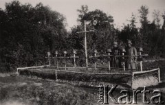 1940, Francja.
 Dwaj żołnierze Wehrmachtu przy zbiorowej mogile poległych żołnierzy niemieckich. Na czterech krzyżach tabliczki z nazwiskami poległych, na pozostałych czterech brak takich tabliczek Na wszystkich  krzyżach założone hełmy wz 35.
 Fot. NN, zbiory Ośrodka KARTA, udostępnił Stanisław Blichiewicz
   
