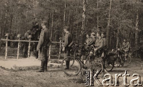 1941, ZSRR.
 Żołnierze niemieccy z jednostki kolarzy stoją przy mogile poległych kolegów. Na pierwszym planie od  prawej: kapral, starszy szeregowy i dwaj szeregowi operatorzy radiostacji (na ramieniu okrągła oznaka z błyskawicą), dwaj szeregowi, starszy sierżant. Za mogiłami na drugim planie stoi od prawej plutonowy i siedzi na koniu starszy sierżant.
 Fot. NN, zbiory Ośrodka KARTA, udostępnił Stanisław Blichiewicz
   
