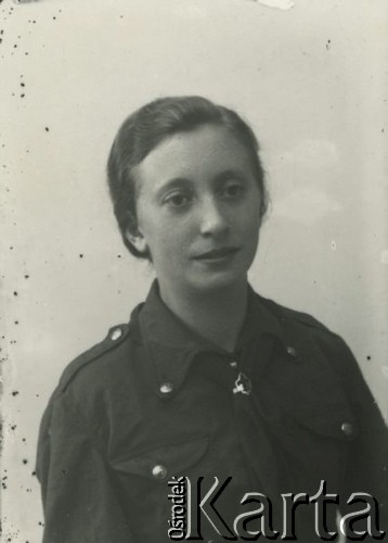 Druga połowa lat 30. do 1939, Kozienice, Polska.
Rochama Frajlich, córka młynarza Szmula Eli. Nauczycielka w getcie kozienickim (do września 1942). Portret wykonany przed wojną - Rochama w mundurze harcerskim. Rochama Frajlich przeżyła wojnę.
Zdjęcie wykonane w atelier fotograficznym żydowskiego fotografa Chaima Bernemana. Przed wojną zakład mieścił się w Kozienicach na rogu ulic Warszawskiej i Maciejowickiej, przed wybuchem wojny albo już w czasie niemieckiej okupacji  został przeniesiony na ulicę Lubelską 13. Cała kolekcja jest datowana na okres od drugiej połowy lat 30-tych do roku 1941, kiedy Chaim Berneman wraz z rodziną został zesłany do obozu pracy w Wolanowie. Berneman zmarł po ucieczce z obozu.
Fot. Chaim Berneman (Chaim Berman), zbiory Ośrodka KARTA