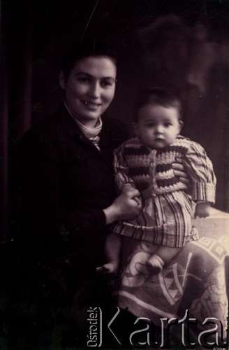 Druga połowa lat 30. do 1941, Kozienice, Polska.
Portret młodej kobiety z dzieckiem.
Zdjęcie wykonane w atelier fotograficznym żydowskiego fotografa Chaima Bernemana. Przed wojną zakład mieścił się w Kozienicach na rogu ulic Warszawskiej i Maciejowickiej, przed wybuchem wojny albo już w czasie niemieckiej okupacji  został przeniesiony na ulicę Lubelską 13. Cała kolekcja jest datowana na okres od drugiej połowy lat 30-tych do roku 1941, kiedy Chaim Berneman wraz z rodziną został zesłany do obozu pracy w Wolanowie. Berneman zmarł po ucieczce z obozu.
Fot. Chaim Berneman (Chaim Berman), zbiory Ośrodka KARTA