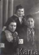 1939-1941, Kozienice, Polska.
Portret trzech młodych Żydówek z opaskami na rękawach płaszczy.
Zdjęcie wykonane w atelier fotograficznym żydowskiego fotografa Chaima Bernemana. Przed wojną zakład mieścił się w Kozienicach na rogu ulic Warszawskiej i Maciejowickiej, przed wybuchem wojny albo już w czasie niemieckiej okupacji  został przeniesiony na ulicę Lubelską 13. Cała kolekcja jest datowana na okres od drugiej połowy lat 30-tych do roku 1941, kiedy Chaim Berneman wraz z rodziną został zesłany do obozu pracy w Wolanowie. Berneman zmarł po ucieczce z obozu.
Fot. Chaim Berneman (Chaim Berman), zbiory Ośrodka KARTA