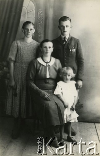 Druga połowa lat 30. do 1941, Kozienice, Polska.
Kobieta z dzieckiem oraz dziewczyna i chłopak.
Zdjęcie wykonane w atelier fotograficznym żydowskiego fotografa Chaima Bernemana. Przed wojną zakład mieścił się w Kozienicach na rogu ulic Warszawskiej i Maciejowickiej, przed wybuchem wojny albo już w czasie niemieckiej okupacji  został przeniesiony na ulicę Lubelską 13. Cała kolekcja jest datowana na okres od drugiej połowy lat 30-tych do roku 1941, kiedy Chaim Berneman wraz z rodziną został zesłany do obozu pracy w Wolanowie. Berneman zmarł po ucieczce z obozu.
Fot. Chaim Berneman (Chaim Berman), zbiory Ośrodka KARTA