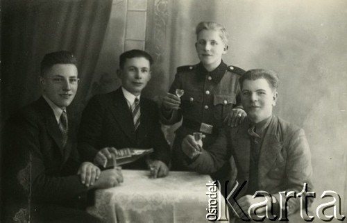 1939-1941, Kozienice, Polska.
Portret czterech młodych mężczyzn z butelką alkoholu i kieliszkami. Jeden z mężczyzn jest w mundurze.
Zdjęcie wykonane w atelier fotograficznym żydowskiego fotografa Chaima Bernemana. Przed wojną zakład mieścił się w Kozienicach na rogu ulic Warszawskiej i Maciejowickiej, przed wybuchem wojny albo już w czasie niemieckiej okupacji  został przeniesiony na ulicę Lubelską 13. Cała kolekcja jest datowana na okres od drugiej połowy lat 30-tych do roku 1941, kiedy Chaim Berneman wraz z rodziną został zesłany do obozu pracy w Wolanowie. Berneman zmarł po ucieczce z obozu.
Fot. Chaim Berneman (Chaim Berman), zbiory Ośrodka KARTA