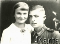 1939-1941, Kozienice, Polska.
Niemiecki policjant i młoda kobieta.
Zdjęcie wykonane w atelier fotograficznym żydowskiego fotografa Chaima Bernemana. Przed wojną zakład mieścił się w Kozienicach na rogu ulic Warszawskiej i Maciejowickiej, przed wybuchem wojny albo już w czasie niemieckiej okupacji  został przeniesiony na ulicę Lubelską 13. Cała kolekcja jest datowana na okres od drugiej połowy lat 30-tych do roku 1941, kiedy Chaim Berneman wraz z rodziną został zesłany do obozu pracy w Wolanowie. Berneman zmarł po ucieczce z obozu.
Fot. Chaim Berneman (Chaim Berman), zbiory Ośrodka KARTA