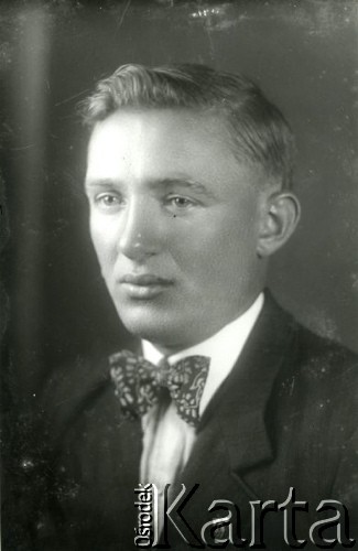 1939-1941, Kozienice, Polska.
Młody mężczyzna z odznaką jednej z organizacji nazistowskich w klapie marynarki.
Zdjęcie wykonane w atelier fotograficznym żydowskiego fotografa Chaima Bernemana. Przed wojną zakład mieścił się w Kozienicach na rogu ulic Warszawskiej i Maciejowickiej, przed wybuchem wojny albo już w czasie niemieckiej okupacji  został przeniesiony na ulicę Lubelską 13. Cała kolekcja jest datowana na okres od drugiej połowy lat 30-tych do roku 1941, kiedy Chaim Berneman wraz z rodziną został zesłany do obozu pracy w Wolanowie. Berneman zmarł po ucieczce z obozu.
Fot. Chaim Berneman (Chaim Berman), zbiory Ośrodka KARTA