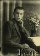 Druga połowa lat 30. do 1941, Kozienice, Polska.
Portret chłopca w marynarce, na stoliku leży otwarta książka i stoi bukiet kwiatów.
Zdjęcie wykonane w atelier fotograficznym żydowskiego fotografa Chaima Bernemana. Przed wojną zakład mieścił się w Kozienicach na rogu ulic Warszawskiej i Maciejowickiej, przed wybuchem wojny albo już w czasie niemieckiej okupacji  został przeniesiony na ulicę Lubelską 13. Cała kolekcja jest datowana na okres od drugiej połowy lat 30-tych do roku 1941, kiedy Chaim Berneman wraz z rodziną został zesłany do obozu pracy w Wolanowie. Berneman zmarł po ucieczce z obozu.
Fot. Chaim Berneman (Chaim Berman), zbiory Ośrodka KARTA