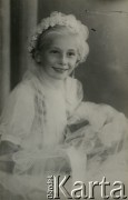 Druga połowa lat 30. do 1939, Kozienice, Polska.
Pamiątka Pierwszej Komunii Świętej - portret dziewczynki w białej sukience.
Zdjęcie wykonane w atelier fotograficznym żydowskiego fotografa Chaima Bernemana. Przed wojną zakład mieścił się w Kozienicach na rogu ulic Warszawskiej i Maciejowickiej, tuż przed wybuchem wojny albo już w czasie niemieckiej okupacji  został przeniesiony na ulicę Lubelską 13. Cała kolekcja jest datowana na okres od drugiej połowy lat 30-tych do roku 1941, kiedy Chaim Berneman wraz z rodziną został zesłany do obozu pracy w Wolanowie. Berneman zmarł po ucieczce z obozu.
Fot. Chaim Berneman (Chaim Berman), zbiory Ośrodka KARTA