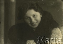 Druga połowa lat 30. do 1941, Kozienice, Polska.
Portret młodej kobiety w czapce i płaszczu z futrzanym kołnierzem.
Zdjęcie wykonane w atelier fotograficznym żydowskiego fotografa Chaima Bernemana. Przed wojną zakład mieścił się w Kozienicach na rogu ulic Warszawskiej i Maciejowickiej, przed wybuchem wojny albo już w czasie niemieckiej okupacji  został przeniesiony na ulicę Lubelską 13. Cała kolekcja jest datowana na okres od drugiej połowy lat 30-tych do roku 1941, kiedy Chaim Berneman wraz z rodziną został zesłany do obozu pracy w Wolanowie. Berneman zmarł po ucieczce z obozu.
Fot. Chaim Berneman (Chaim Berman), zbiory Ośrodka KARTA