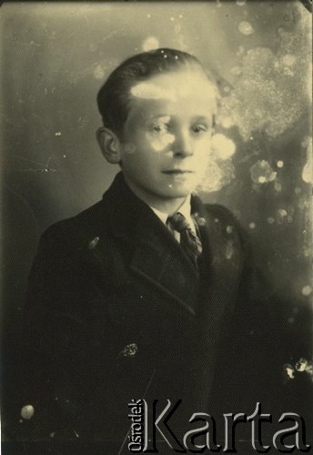 Druga połowa lat 30. do 1941, Kozienice, Polska.
Portret chłopca w marynarce, jasnej koszuli i krawacie.
Zdjęcie wykonane w atelier fotograficznym żydowskiego fotografa Chaima Bernemana. Przed wojną zakład mieścił się w Kozienicach na rogu ulic Warszawskiej i Maciejowickiej, przed wybuchem wojny albo już w czasie niemieckiej okupacji  został przeniesiony na ulicę Lubelską 13. Cała kolekcja jest datowana na okres od drugiej połowy lat 30-tych do roku 1941, kiedy Chaim Berneman wraz z rodziną został zesłany do obozu pracy w Wolanowie. Berneman zmarł po ucieczce z obozu.
Fot. Chaim Berneman (Chaim Berman), zbiory Ośrodka KARTA