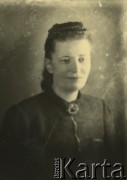Druga połowa lat 30. do 1941, Kozienice, Polska.
Portret młodej kobiety w ciemnej bluzce spiętej broszką.
Zdjęcie wykonane w atelier fotograficznym żydowskiego fotografa Chaima Bernemana. Przed wojną zakład mieścił się w Kozienicach na rogu ulic Warszawskiej i Maciejowickiej, przed wybuchem wojny albo już w czasie niemieckiej okupacji  został przeniesiony na ulicę Lubelską 13. Cała kolekcja jest datowana na okres od drugiej połowy lat 30-tych do roku 1941, kiedy Chaim Berneman wraz z rodziną został zesłany do obozu pracy w Wolanowie. Berneman zmarł po ucieczce z obozu.
Fot. Chaim Berneman (Chaim Berman), zbiory Ośrodka KARTA