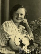 Druga połowa lat 30. do 1941, Kozienice, Polska.
Portret dziewczyny w bluzce w paski.
Zdjęcie wykonane w atelier fotograficznym żydowskiego fotografa Chaima Bernemana. Przed wojną zakład mieścił się w Kozienicach na rogu ulic Warszawskiej i Maciejowickiej, przed wybuchem wojny albo już w czasie niemieckiej okupacji  został przeniesiony na ulicę Lubelską 13. Cała kolekcja jest datowana na okres od drugiej połowy lat 30-tych do roku 1941, kiedy Chaim Berneman wraz z rodziną został zesłany do obozu pracy w Wolanowie. Berneman zmarł po ucieczce z obozu.
Fot. Chaim Berneman (Chaim Berman), zbiory Ośrodka KARTA