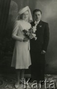 Druga połowa lat 30. do 1939, Kozienice, Polska.
Młoda para, fotografia ślubna. Kobieta trzyma bukiet kwiatów.
Zdjęcie wykonane w atelier fotograficznym żydowskiego fotografa Chaima Bernemana. Przed wojną zakład mieścił się w Kozienicach na rogu ulic Warszawskiej i Maciejowickiej, przed wybuchem wojny albo już w czasie niemieckiej okupacji  został przeniesiony na ulicę Lubelską 13. Cała kolekcja jest datowana na okres od drugiej połowy lat 30-tych do roku 1941, kiedy Chaim Berneman wraz z rodziną został zesłany do obozu pracy w Wolanowie. Berneman zmarł po ucieczce z obozu.
Fot. Chaim Berneman (Chaim Berman), zbiory Ośrodka KARTA