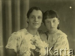 Druga połowa lat 30. do 1941, Kozienice, Polska.
Młoda kobieta w jasnej bluzce i dziewczynka, portret. Prawdopodobnie matka z córką.
Zdjęcie wykonane w atelier fotograficznym żydowskiego fotografa Chaima Bernemana. Przed wojną zakład mieścił się w Kozienicach na rogu ulic Warszawskiej i Maciejowickiej, przed wybuchem wojny albo już w czasie niemieckiej okupacji  został przeniesiony na ulicę Lubelską 13. Cała kolekcja jest datowana na okres od drugiej połowy lat 30-tych do roku 1941, kiedy Chaim Berneman wraz z rodziną został zesłany do obozu pracy w Wolanowie. Berneman zmarł po ucieczce z obozu.
Fot. Chaim Berneman (Chaim Berman), zbiory Ośrodka KARTA