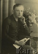 Druga połowa lat 30. do 1941, Kozienice, Polska.
Portret chłopca w ciemnej koszuli, na stoliku stoi bukiet bzu.
Zdjęcie wykonane w atelier fotograficznym żydowskiego fotografa Chaima Bernemana. Przed wojną zakład mieścił się w Kozienicach na rogu ulic Warszawskiej i Maciejowickiej, przed wybuchem wojny albo już w czasie niemieckiej okupacji  został przeniesiony na ulicę Lubelską 13. Cała kolekcja jest datowana na okres od drugiej połowy lat 30-tych do roku 1941, kiedy Chaim Berneman wraz z rodziną został zesłany do obozu pracy w Wolanowie. Berneman zmarł po ucieczce z obozu.
Fot. Chaim Berneman (Chaim Berman), zbiory Ośrodka KARTA