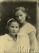 Druga połowa lat 30. do 1941, Kozienice, Polska.
Portret dwóch dziewczynek w jasnych sukienkach.
Zdjęcie wykonane w atelier fotograficznym żydowskiego fotografa Chaima Bernemana. Przed wojną zakład mieścił się w Kozienicach na rogu ulic Warszawskiej i Maciejowickiej, przed wybuchem wojny albo już w czasie niemieckiej okupacji  został przeniesiony na ulicę Lubelską 13. Cała kolekcja jest datowana na okres od drugiej połowy lat 30-tych do roku 1941, kiedy Chaim Berneman wraz z rodziną został zesłany do obozu pracy w Wolanowie. Berneman zmarł po ucieczce z obozu.
Fot. Chaim Berneman (Chaim Berman), zbiory Ośrodka KARTA