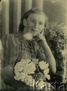 Druga połowa lat 30. do 1941, Kozienice, Polska.
Portret kobiety z bukietem kwiatów.
Zdjęcie wykonane w atelier fotograficznym żydowskiego fotografa Chaima Bernemana. Przed wojną zakład mieścił się w Kozienicach na rogu ulic Warszawskiej i Maciejowickiej, przed wybuchem wojny albo już w czasie niemieckiej okupacji  został przeniesiony na ulicę Lubelską 13. Cała kolekcja jest datowana na okres od drugiej połowy lat 30-tych do roku 1941, kiedy Chaim Berneman wraz z rodziną został zesłany do obozu pracy w Wolanowie. Berneman zmarł po ucieczce z obozu.
Fot. Chaim Berneman (Chaim Berman), zbiory Ośrodka KARTA