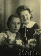 Druga połowa lat 30. do 1941, Kozienice, Polska.
Portret dwóch dziewczyn z girlandą kwiatów.
Zdjęcie wykonane w atelier fotograficznym żydowskiego fotografa Chaima Bernemana. Przed wojną zakład mieścił się w Kozienicach na rogu ulic Warszawskiej i Maciejowickiej, przed wybuchem wojny albo już w czasie niemieckiej okupacji  został przeniesiony na ulicę Lubelską 13. Cała kolekcja jest datowana na okres od drugiej połowy lat 30-tych do roku 1941, kiedy Chaim Berneman wraz z rodziną został zesłany do obozu pracy w Wolanowie. Berneman zmarł po ucieczce z obozu.
Fot. Chaim Berneman (Chaim Berman), zbiory Ośrodka KARTA