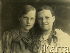 Druga połowa lat 30. do 1941, Kozienice, Polska.
Portret dwóch dziewczynek z warkoczami.
Zdjęcie wykonane w atelier fotograficznym żydowskiego fotografa Chaima Bernemana. Przed wojną zakład mieścił się w Kozienicach na rogu ulic Warszawskiej i Maciejowickiej, przed wybuchem wojny albo już w czasie niemieckiej okupacji  został przeniesiony na ulicę Lubelską 13. Cała kolekcja jest datowana na okres od drugiej połowy lat 30-tych do roku 1941, kiedy Chaim Berneman wraz z rodziną został zesłany do obozu pracy w Wolanowie. Berneman zmarł po ucieczce z obozu.
Fot. Chaim Berneman (Chaim Berman), zbiory Ośrodka KARTA