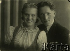 Druga połowa lat 30. do 1941, Kozienice, Polska.
Portret dziewczyny w białej bluzce i chłopaka w marynarce i krawacie.
Zdjęcie wykonane w atelier fotograficznym żydowskiego fotografa Chaima Bernemana. Przed wojną zakład mieścił się w Kozienicach na rogu ulic Warszawskiej i Maciejowickiej, przed wybuchem wojny albo już w czasie niemieckiej okupacji  został przeniesiony na ulicę Lubelską 13. Cała kolekcja jest datowana na okres od drugiej połowy lat 30-tych do roku 1941, kiedy Chaim Berneman wraz z rodziną został zesłany do obozu pracy w Wolanowie. Berneman zmarł po ucieczce z obozu.
Fot. Chaim Berneman (Chaim Berman), zbiory Ośrodka KARTA