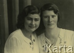 Druga połowa lat 30. do 1941, Kozienice, Polska.
Portret dwóch dziewczyn w białych bluzkach.
Zdjęcie wykonane w atelier fotograficznym żydowskiego fotografa Chaima Bernemana. Przed wojną zakład mieścił się w Kozienicach na rogu ulic Warszawskiej i Maciejowickiej, przed wybuchem wojny albo już w czasie niemieckiej okupacji  został przeniesiony na ulicę Lubelską 13. Cała kolekcja jest datowana na okres od drugiej połowy lat 30-tych do roku 1941, kiedy Chaim Berneman wraz z rodziną został zesłany do obozu pracy w Wolanowie. Berneman zmarł po ucieczce z obozu.
Fot. Chaim Berneman (Chaim Berman), zbiory Ośrodka KARTA