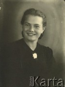 Druga połowa lat 30. do 1941, Kozienice, Polska.
Portret dziewczyny w czarnej bluzce z kwiatem wpiętym pod szyją.
Zdjęcie wykonane w atelier fotograficznym żydowskiego fotografa Chaima Bernemana. Przed wojną zakład mieścił się w Kozienicach na rogu ulic Warszawskiej i Maciejowickiej, przed wybuchem wojny albo już w czasie niemieckiej okupacji  został przeniesiony na ulicę Lubelską 13. Cała kolekcja jest datowana na okres od drugiej połowy lat 30-tych do roku 1941, kiedy Chaim Berneman wraz z rodziną został zesłany do obozu pracy w Wolanowie. Berneman zmarł po ucieczce z obozu.
Fot. Chaim Berneman (Chaim Berman), zbiory Ośrodka KARTA