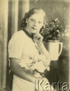 Druga połowa lat 30. do 1941, Kozienice, Polska.
Portret dziewczyny w jasnej sukience.
Zdjęcie wykonane w atelier fotograficznym żydowskiego fotografa Chaima Bernemana. Przed wojną zakład mieścił się w Kozienicach na rogu ulic Warszawskiej i Maciejowickiej, przed wybuchem wojny albo już w czasie niemieckiej okupacji  został przeniesiony na ulicę Lubelską 13. Cała kolekcja jest datowana na okres od drugiej połowy lat 30-tych do roku 1941, kiedy Chaim Berneman wraz z rodziną został zesłany do obozu pracy w Wolanowie. Berneman zmarł po ucieczce z obozu.
Fot. Chaim Berneman (Chaim Berman), zbiory Ośrodka KARTA