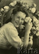 Druga połowa lat 30. do 1941, Kozienice, Polska.
Portret dziewczyny z kwiatami.
Zdjęcie wykonane w atelier fotograficznym żydowskiego fotografa Chaima Bernemana. Przed wojną zakład mieścił się w Kozienicach na rogu ulic Warszawskiej i Maciejowickiej, przed wybuchem wojny albo już w czasie niemieckiej okupacji  został przeniesiony na ulicę Lubelską 13. Cała kolekcja jest datowana na okres od drugiej połowy lat 30-tych do roku 1941, kiedy Chaim Berneman wraz z rodziną został zesłany do obozu pracy w Wolanowie. Berneman zmarł po ucieczce z obozu.
Fot. Chaim Berneman (Chaim Berman), zbiory Ośrodka KARTA