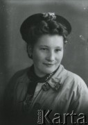 Druga połowa lat 30. do 1941, Kozienice, Polska.
Portret młodej kobiety w płaszczu i berecie.
Zdjęcie wykonane w atelier fotograficznym żydowskiego fotografa Chaima Bernemana. Przed wojną zakład mieścił się w Kozienicach na rogu ulic Warszawskiej i Maciejowickiej, przed wybuchem wojny albo już w czasie niemieckiej okupacji  został przeniesiony na ulicę Lubelską 13. Cała kolekcja jest datowana na okres od drugiej połowy lat 30-tych do roku 1941, kiedy Chaim Berneman wraz z rodziną został zesłany do obozu pracy w Wolanowie. Berneman zmarł po ucieczce z obozu.
Fot. Chaim Berneman (Chaim Berman), zbiory Ośrodka KARTA