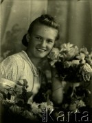 Druga połowa lat 30. do 1941, Kozienice, Polska.
Portret dziewczyny z girlandą kwiatów.
Zdjęcie wykonane w atelier fotograficznym żydowskiego fotografa Chaima Bernemana. Przed wojną zakład mieścił się w Kozienicach na rogu ulic Warszawskiej i Maciejowickiej, przed wybuchem wojny albo już w czasie niemieckiej okupacji  został przeniesiony na ulicę Lubelską 13. Cała kolekcja jest datowana na okres od drugiej połowy lat 30-tych do roku 1941, kiedy Chaim Berneman wraz z rodziną został zesłany do obozu pracy w Wolanowie. Berneman zmarł po ucieczce z obozu.
Fot. Chaim Berneman (Chaim Berman), zbiory Ośrodka KARTA