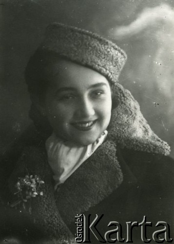Druga połowa lat 30. do 1941, Kozienice, Polska.
Portret młodej kobiety w zimowym palcie i toczku na głowie.
Zdjęcie wykonane w atelier fotograficznym żydowskiego fotografa Chaima Bernemana. Przed wojną zakład mieścił się w Kozienicach na rogu ulic Warszawskiej i Maciejowickiej, przed wybuchem wojny albo już w czasie niemieckiej okupacji  został przeniesiony na ulicę Lubelską 13. Cała kolekcja jest datowana na okres od drugiej połowy lat 30-tych do roku 1941, kiedy Chaim Berneman wraz z rodziną został zesłany do obozu pracy w Wolanowie. Berneman zmarł po ucieczce z obozu.
Fot. Chaim Berneman (Chaim Berman), zbiory Ośrodka KARTA