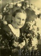 Druga połowa lat 30. do 1941, Kozienice, Polska.
Portret młodej kobiety z girlandą kwiatów.
Zdjęcie wykonane w atelier fotograficznym żydowskiego fotografa Chaima Bernemana. Przed wojną zakład mieścił się w Kozienicach na rogu ulic Warszawskiej i Maciejowickiej, przed wybuchem wojny albo już w czasie niemieckiej okupacji  został przeniesiony na ulicę Lubelską 13. Cała kolekcja jest datowana na okres od drugiej połowy lat 30-tych do roku 1941, kiedy Chaim Berneman wraz z rodziną został zesłany do obozu pracy w Wolanowie. Berneman zmarł po ucieczce z obozu.
Fot. Chaim Berneman (Chaim Berman), zbiory Ośrodka KARTA