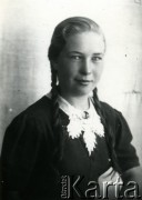 Druga połowa lat 30. do 1941, Kozienice, Polska.
Portret dziewczyny z warkoczami, w ciemnej bluzce z białym kołnierzykiem.
Zdjęcie wykonane w atelier fotograficznym żydowskiego fotografa Chaima Bernemana. Przed wojną zakład mieścił się w Kozienicach na rogu ulic Warszawskiej i Maciejowickiej, przed wybuchem wojny albo już w czasie niemieckiej okupacji  został przeniesiony na ulicę Lubelską 13. Cała kolekcja jest datowana na okres od drugiej połowy lat 30-tych do roku 1941, kiedy Chaim Berneman wraz z rodziną został zesłany do obozu pracy w Wolanowie. Berneman zmarł po ucieczce z obozu.
Fot. Chaim Berneman (Chaim Berman), zbiory Ośrodka KARTA