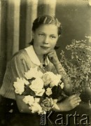 Druga połowa lat 30. do 1941, Kozienice, Polska.
Portret dziewczyny z kwiatami.
Zdjęcie wykonane w atelier fotograficznym żydowskiego fotografa Chaima Bernemana. Przed wojną zakład mieścił się w Kozienicach na rogu ulic Warszawskiej i Maciejowickiej, przed wybuchem wojny albo już w czasie niemieckiej okupacji  został przeniesiony na ulicę Lubelską 13. Cała kolekcja jest datowana na okres od drugiej połowy lat 30-tych do roku 1941, kiedy Chaim Berneman wraz z rodziną został zesłany do obozu pracy w Wolanowie. Berneman zmarł po ucieczce z obozu.
Fot. Chaim Berneman (Chaim Berman), zbiory Ośrodka KARTA