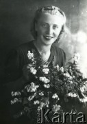 Druga połowa lat 30. do 1941, Kozienice, Polska.
Portret młodej kobiety z bukietem kwiatów.
Zdjęcie wykonane w atelier fotograficznym żydowskiego fotografa Chaima Bernemana. Przed wojną zakład mieścił się w Kozienicach na rogu ulic Warszawskiej i Maciejowickiej, przed wybuchem wojny albo już w czasie niemieckiej okupacji  został przeniesiony na ulicę Lubelską 13. Cała kolekcja jest datowana na okres od drugiej połowy lat 30-tych do roku 1941, kiedy Chaim Berneman wraz z rodziną został zesłany do obozu pracy w Wolanowie. Berneman zmarł po ucieczce z obozu.
Fot. Chaim Berneman (Chaim Berman), zbiory Ośrodka KARTA