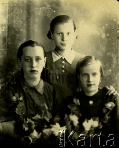 Druga połowa lat 30. do 1941, Kozienice, Polska.
Portret trzech dziewczynek z kwiatami.
Zdjęcie wykonane w atelier fotograficznym żydowskiego fotografa Chaima Bernemana. Przed wojną zakład mieścił się w Kozienicach na rogu ulic Warszawskiej i Maciejowickiej, przed wybuchem wojny albo już w czasie niemieckiej okupacji  został przeniesiony na ulicę Lubelską 13. Cała kolekcja jest datowana na okres od drugiej połowy lat 30-tych do roku 1941, kiedy Chaim Berneman wraz z rodziną został zesłany do obozu pracy w Wolanowie. Berneman zmarł po ucieczce z obozu.
Fot. Chaim Berneman (Chaim Berman), zbiory Ośrodka KARTA